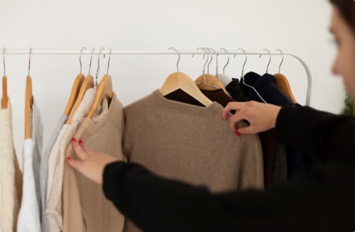 femme qui cherche des vetements sur cintres