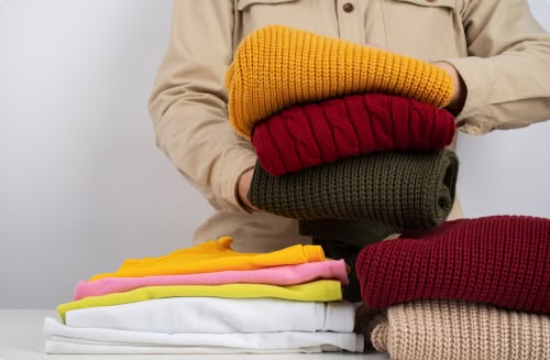 femme qui porte une pile de pull